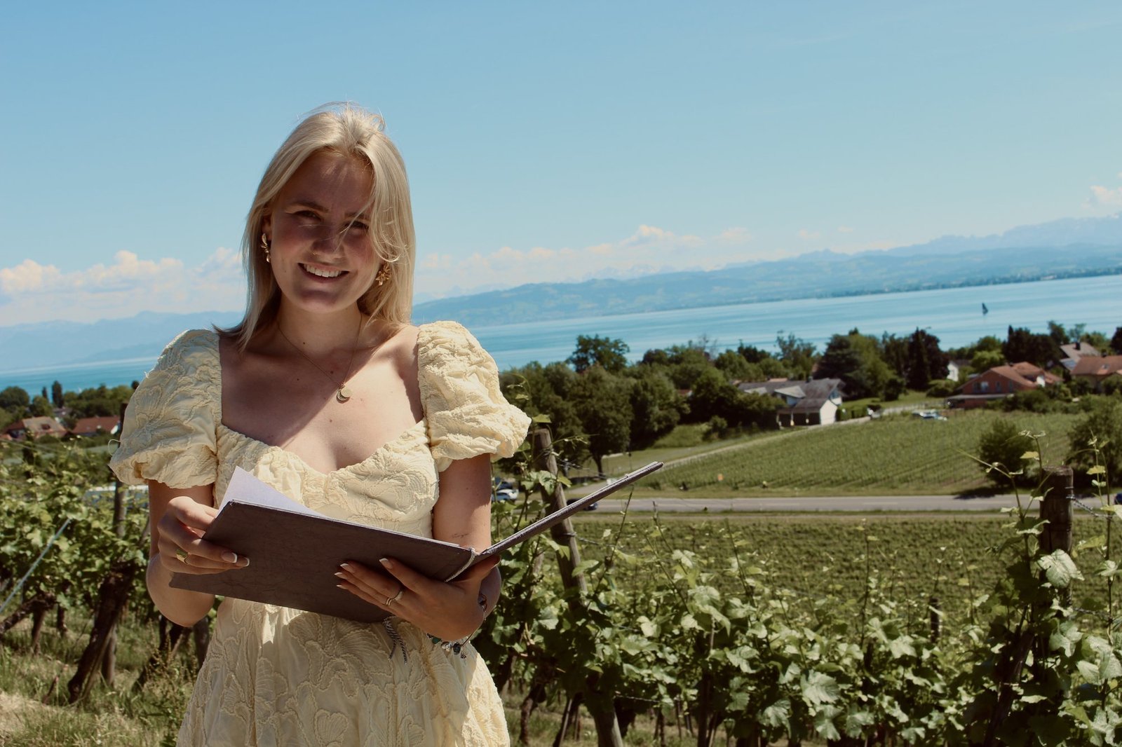Janina lächelt in die Kamera, sie steht in einem Weinberg am Bodensee